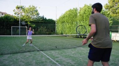 Tenis koçu güneşli bir günde bir kadını eğitiyor. . 