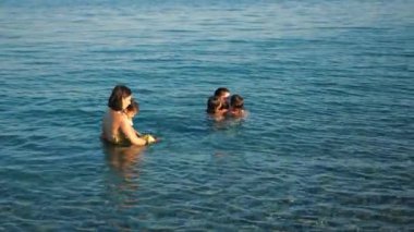 Neşeli bir aile Denizde bir günün tadını çıkarıyor.