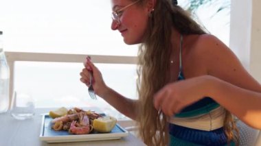 Kadınlar sahilde güzel yemeklerin tadını çıkarıyorlar. 