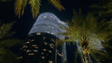 Aydınlatılmış gökdelenin gece alt manzarası.