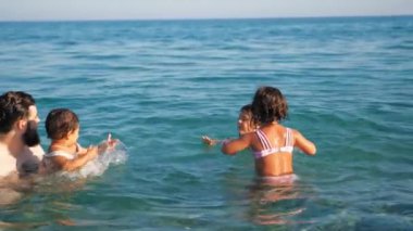 Neşeli bir aile Denizde bir günün tadını çıkarıyor.