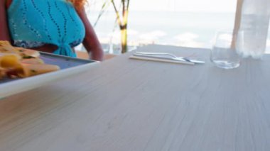 Kadınlar sahilde güzel yemeklerin tadını çıkarıyorlar. 