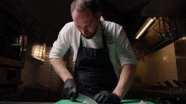 Şef bir mürekkepbalığını dilimlemek için bıçak kullanıyor. .