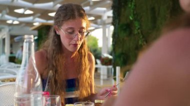 Kadınlar sahilde güzel yemeklerin tadını çıkarıyorlar. 