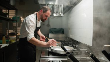 Şef kızartma tavasını yemek için hazırlıyor. . 