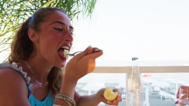 Kadınlar sahilde güzel yemeklerin tadını çıkarıyorlar. 