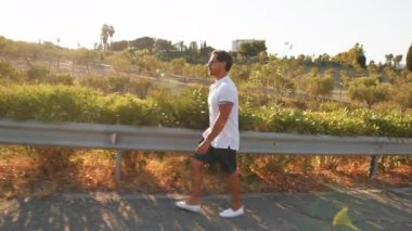 Kırsalda güneşli bir günde yürüyen bir adam 