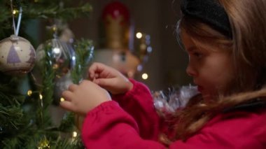 Noel ağacı süsleyen küçük kız . 