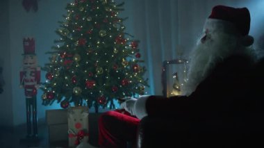 Noel Baba televizyon seyrediyor ve yeni kanalların tadını çıkarıyor. . 