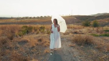 Çimenlerde Şemsiyeyle Yürüyen Kadın . 