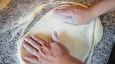 Şef elleriyle pizza hamurunu hazırlıyor. . 