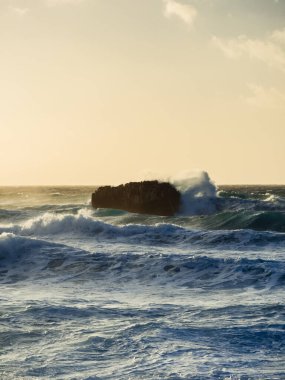 Okyanus dalgaları kayaya çarpar..