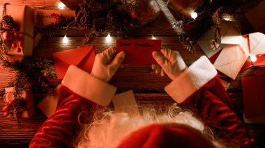 Noel Baba masasında Noel mektupları okuyor..