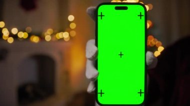Noel Baba yeşil ekranlı akıllı telefonu tutuyor.
