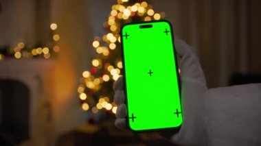 Noel Baba yeşil ekranlı akıllı telefonu tutuyor.