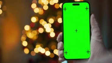 Noel Baba yeşil ekranlı akıllı telefonu tutuyor.
