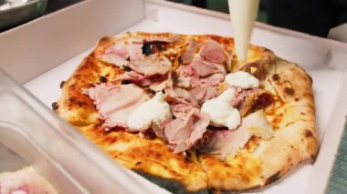 Şef pizzaya Mozzarella sosu ekliyor. . 