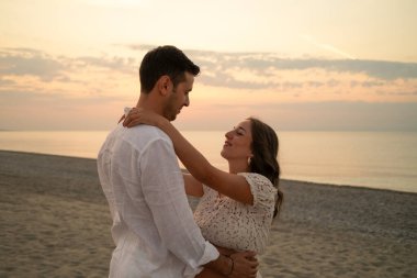 Bir çift gün batımında bebek paylaşımı bekliyor..