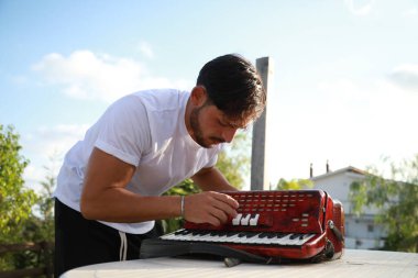 Profesyonel Oyuncu Akordiyonu Düzeltip Ayarlıyor . 