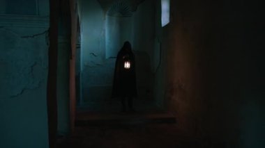 Koyu renk elbiseli bir adam ve yürüyen ve arayan bir fener. 