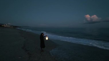 Koyu renk elbiseli bir adam ve yürüyen ve arayan bir fener. 