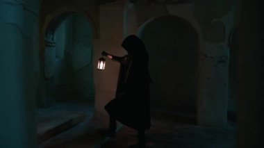 Koyu renk elbiseli bir adam ve yürüyen ve arayan bir fener. 