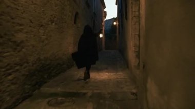 Koyu renk elbiseli bir adam ve yürüyen ve arayan bir fener. 