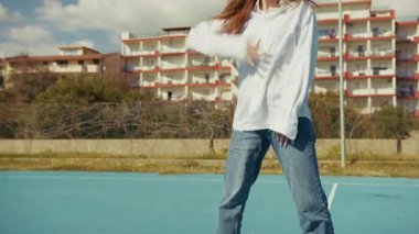 Dansçı basketbol sahasında hareket ediyor ve pratik yapıyor. 