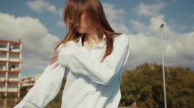 Dansçı basketbol sahasında hareket ediyor ve pratik yapıyor. 