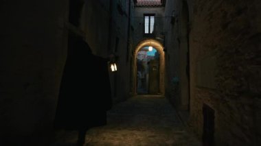 Koyu renk elbiseli bir adam ve yürüyen ve arayan bir fener. 