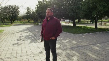 Parktaki adam bilgisayarını tutuyor. .