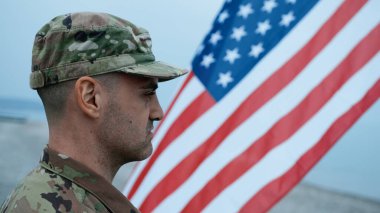 Gururlu bir asker ABD Bayrağını selamlıyor.