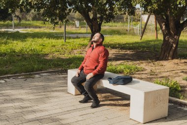 Şehrin parkındaki adam bankta dinleniyor. . 