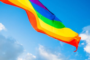 Mavi gökyüzünde LGBTQ dalgalanan bayrak. Yüksek kalite fotoğraf