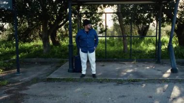 Otobüsün gelmesini ve yolculuğun başlamasını bekleyen bir adam.. 