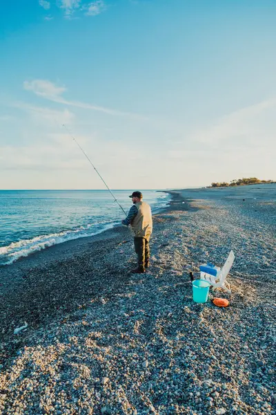 Denizde güneşli bir günde balık tutan adam 