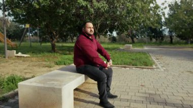 İşten sonra banktaki adam parkta dinleniyor. . 