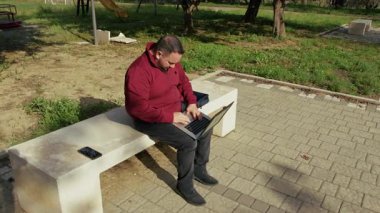 Gündüzleri parkta uzaktan çalışan bir adam. . 