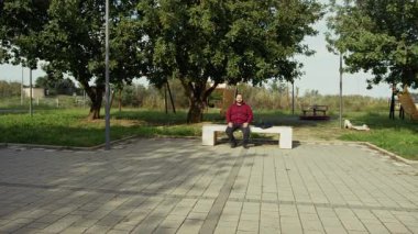 Şehrin parkındaki adam bankta dinleniyor. . 