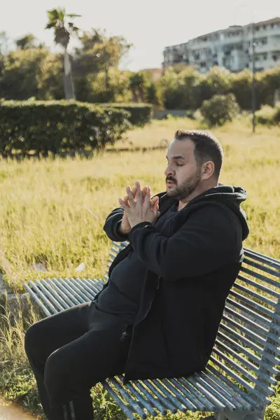 Sıkıcı adam bankta esniyor. . 