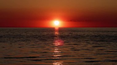 Kırmızı güneş topu gün batımında ufkun arkasında batıyor. Yüksek kalite 4k görüntü