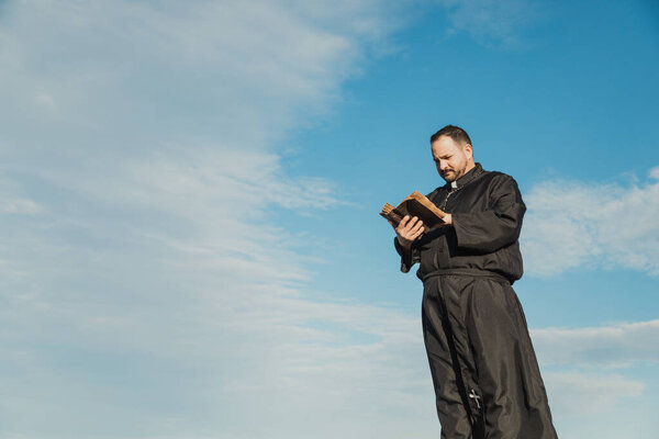 Священник молится в природе в солнечный день 