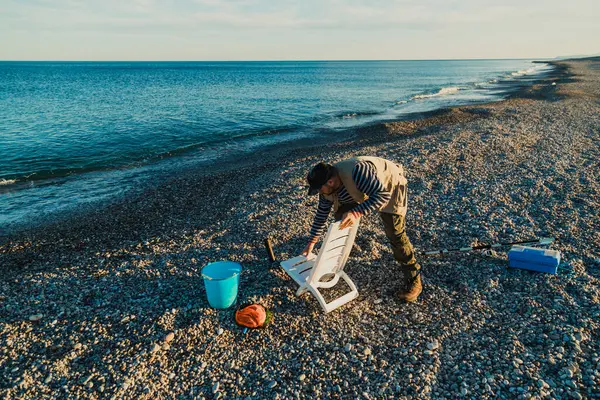 Denizde güneşli bir günde balık tutan adam 