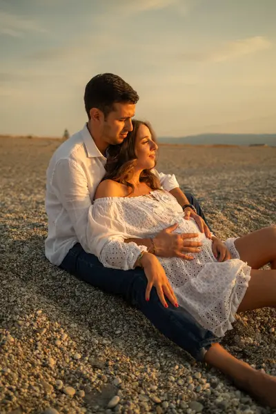 Bir çift gün batımında bebek paylaşımı bekliyor..