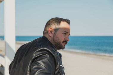 Sahilde güneşli bir gün geçiren bir adam.