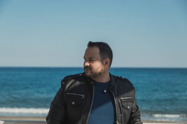 Sahilde güneşli bir gün geçiren bir adam.