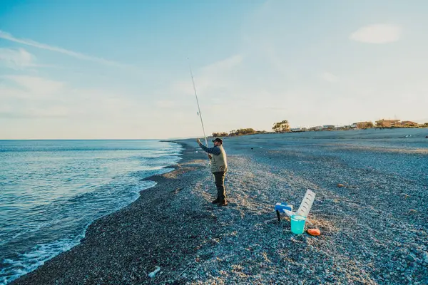 Denizde güneşli bir günde balık tutan adam 