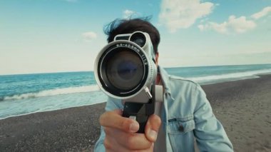 Vintage kameralı bir adam ve denizdeki eski lensleri kullanıyor. . 