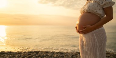 Bir çift gün batımında bebek paylaşımı bekliyor..