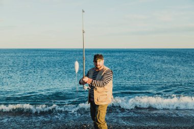Denizde güneşli bir günde balık tutan adam 